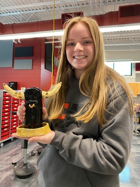 Erie HS student showing off her ceramics piece 